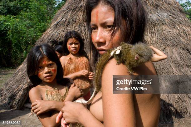 Yagua tribe located near Iquitos, Amazonian, Peru. Portrait of some adolescents living in the village with his pet, a little pygmy marmoset ..