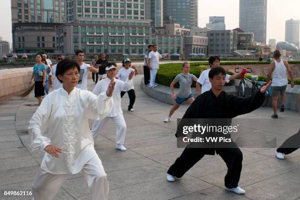 China, Shanghai, morning tai chi exercise on The Bund. Shanghi Bund : Early morning tai chi exercises with swords on the Bund in Shanghai China. The...