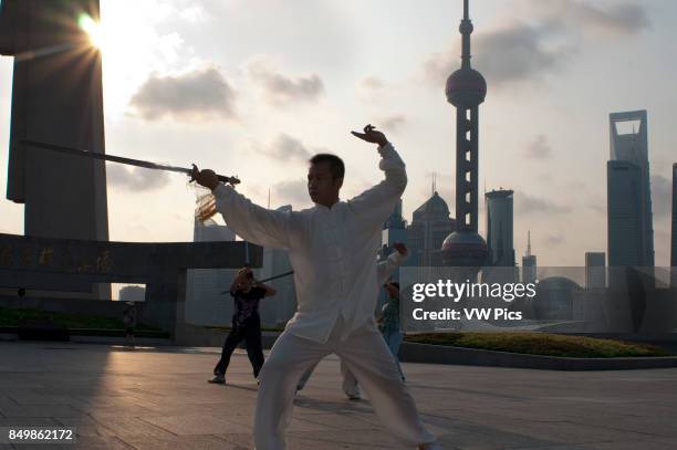 China, Shanghai, morning tai chi exercise on The Bund. Shanghi Bund : Early morning tai chi exercises with swords on the Bund in Shanghai China. The...