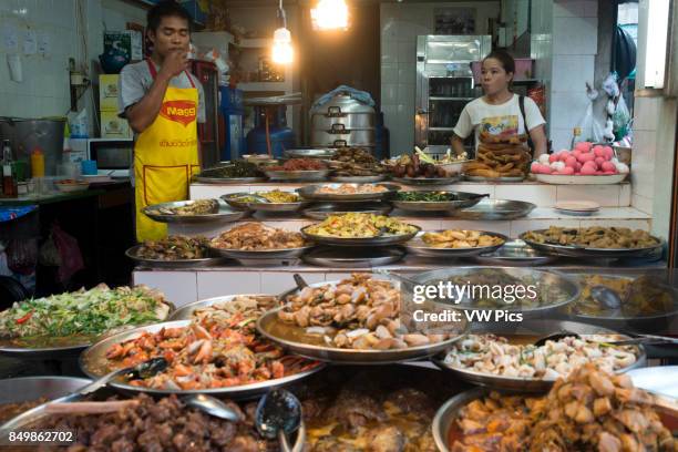Woman selling pring rolls and durian fruits. Bangkok's Chinatown , Thailand. Market stall and street food being prepared in Chinatown Bangkok,...