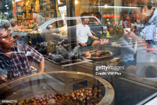 Roast chestnuts , Bangkok's Chinatown , Thailand. Market stall and street food being prepared in Chinatown Bangkok, Thailand. Yaowarat, BangkokÍs...