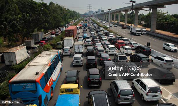 Commuters make a long line on a highway in Jakarta on September 20 with the under construction sky-train line being prepared to solve the traffic...