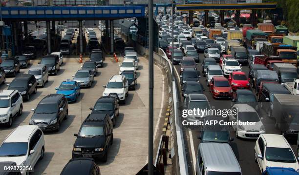 Commuters make a long line on a highway during morning rush hour in Jakarta on September 20, 2017. Indonesias central bank made a surprise 25 basis...