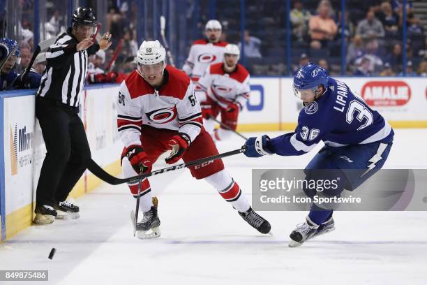 Carolina Hurricanes forward Janne Kuokkanen and Tampa Bay Lightning center Alexei Lipanov battle for the puck in the 3rd period of the NHL preseason...