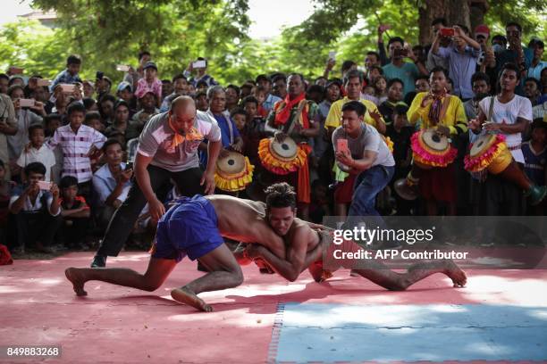 Cambodian men compete in a Khmer wrestling match during the Pchum Ben festival, the festival of death, at Vihear Suor village in Kandal province on...