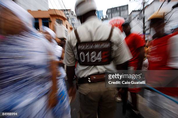 February 22 : Policeman passes by carnival revellers in downtown Salvador, on February 22 Salvador, Brazil.