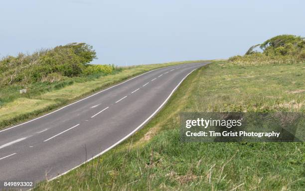 an empty country road - 道端の草地 ストックフォトと画像