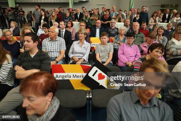 People listen to German Chancellor and Christian Democrat Angela Merkel speak at an election campaign stop on September 19, 2017 in Schwerin,...