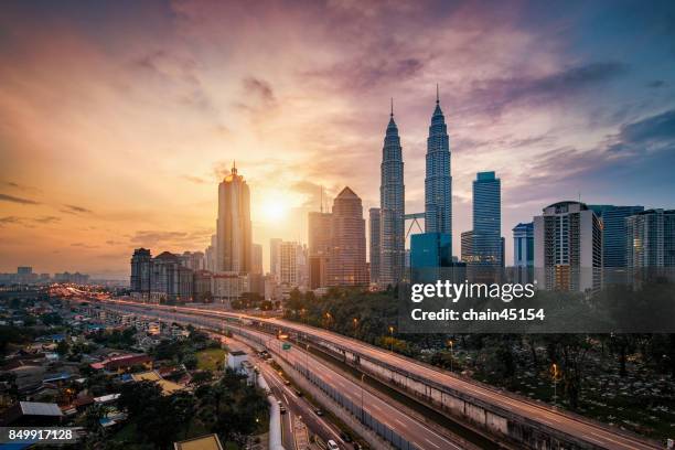 kuala lumpur city centre during sunrise from rooftop of building - kuala lumpur stock-fotos und bilder