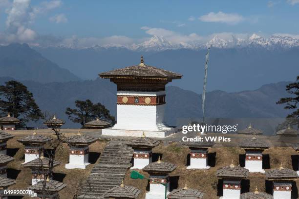 The Druk Wangyal Khang Zhang Chortens are a sacred Bhuddist memorial at Dochu La Pass in Bhutan. In the background center is Mt. Masang Gang or Mt....