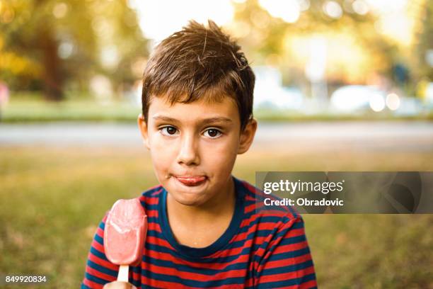 boy  eating popsicle outdoors - candy on tongue stock pictures, royalty-free photos & images