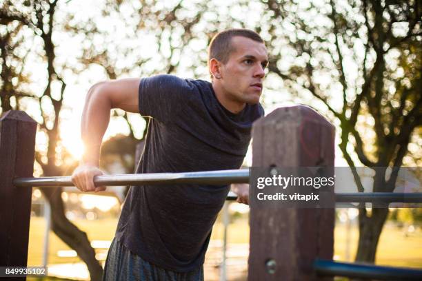 man performing arm exercises at the park - dipping sauce stock pictures, royalty-free photos & images