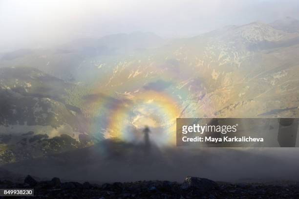 brocken spectre, shadow of a man on top of a mountain - brockengespenst stock-fotos und bilder