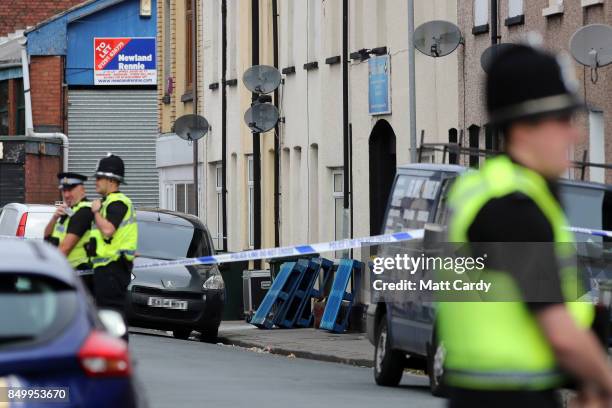 Police officers stand inside a cordon on September 20, 2017 in Newport, Wales. A 48-year-old man and a 30-year-old man have been detained under the...