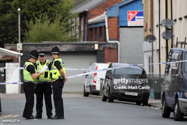 Police officers stand inside a cordon on September 20, 2017 in Newport, Wales. A 48-year-old man and a 30-year-old man have been detained under the...