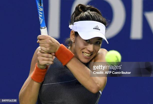 Garbine Muguruza of Spain hits a return against Monica Puig of Puerto Rico during their women's singles second round match at the Pan Pacific Open...