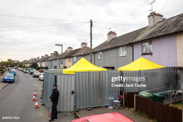 Police officer stands guard by a barrier around a property being searched in connection with the attack on Parsons Green station on September 13,...