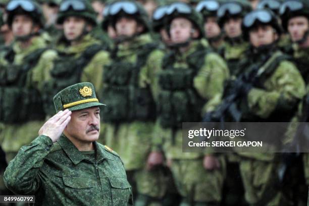 Belarus' President Alexander Lukashenko salutes while standing in front of servicemen during the joint Russian-Belarusian military exercises...