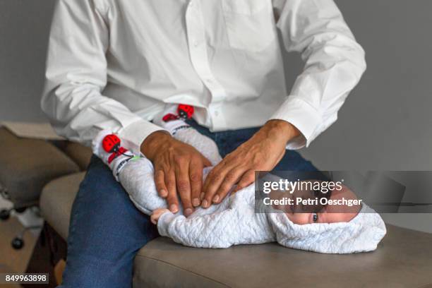 a chiropractor adjusts a one month old baby to help with the relief of colic. - ademhalingsstelsel stockfoto's en -beelden