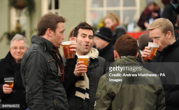 Members of the public enjoy a drink as they line the banks of the Thames before the 159th Boat Race on the River Thames, London.