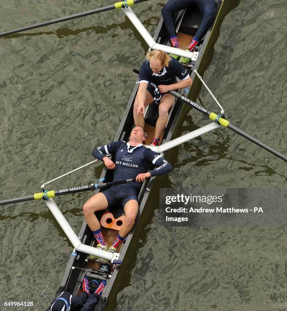 Oxford University's Isis stroke Tom Watson lies down in the boat as he celebrates after his boat wins the reserve Boat Race on the River Thames,...