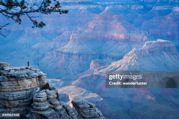 two tourists overlook grand canyon at sunset - mather point stock pictures, royalty-free photos & images