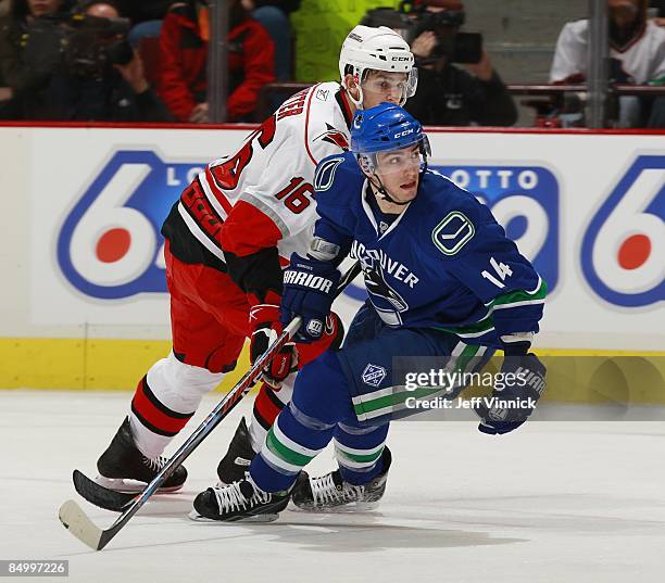 Brandon Sutter of the Carolina Hurricanes and Alex Burrows of the Vancouver Canucks skate up ice during their game at General Motors Place on...