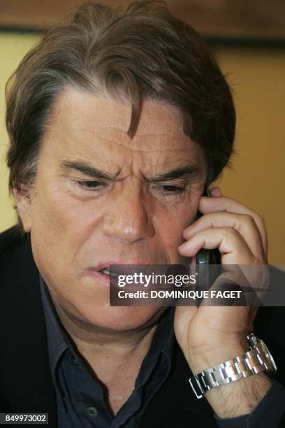 French former businessman Bernard Tapie gives a call prior to a press conference, 10 October 2006 at the Royal Monceau hotel in Paris, one day after...