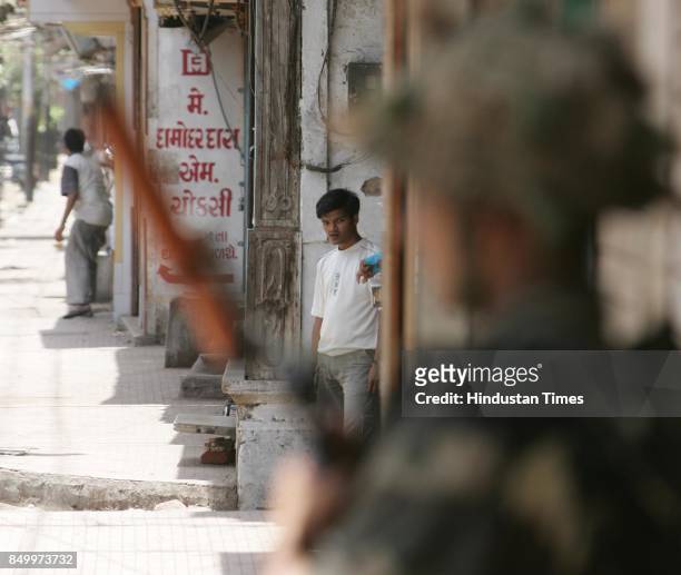 Vadodara Riots: An army jawan guards the doorway in curfew ridden Mandvi in the walled city of Baroda.