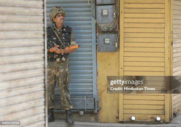 Vadodara Riots: An army jawan guards the doorway in curfew ridden Mandvi in the walled city of Baroda.