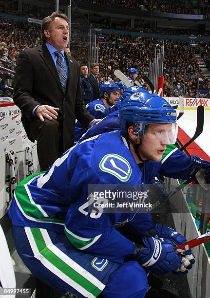 Associate coach Rick Bowness of the Vancouver Canucks looks on from the bench during their game against the Carolina Hurricanes at General Motors...