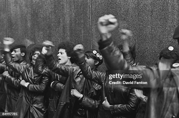 View of a line of Black Panther Party members as they demonstrate, fists raised, outside the New York County Criminal Court , New York, New York,...