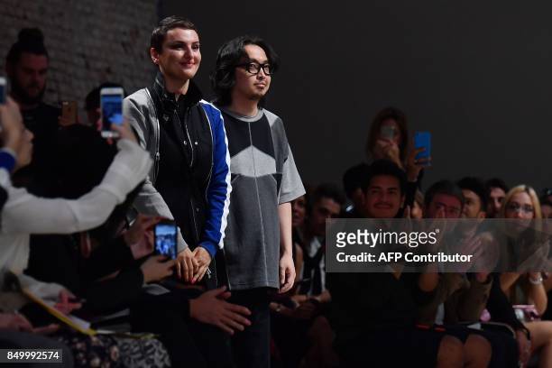 Italian singer Arisa and designer Atsushi Nakashima greet the audience at the end of the show during the Women's Spring/Summer 2018 fashion week in...