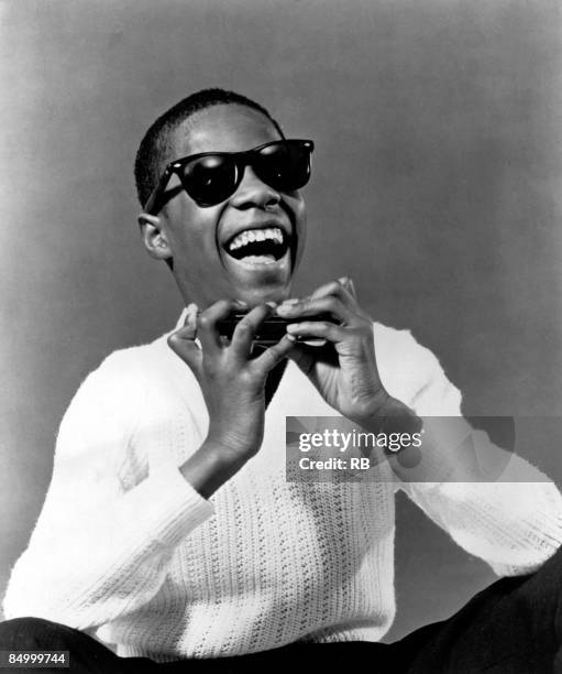 Photo of Stevie WONDER; Posed portrait of Stevie Wonder with a harmonica early 1960's