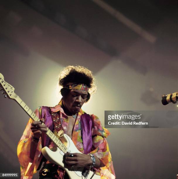 American rock guitarist and singer Jimi Hendrix performs live on stage playing a white Fender Stratocaster guitar with The Jimi Hendrix Experience at...