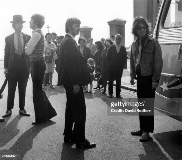 From left, John Lennon, Paul McCartney, Ringo Starr and George Harrison of English rock group The Beatles stand together beside the coach during...
