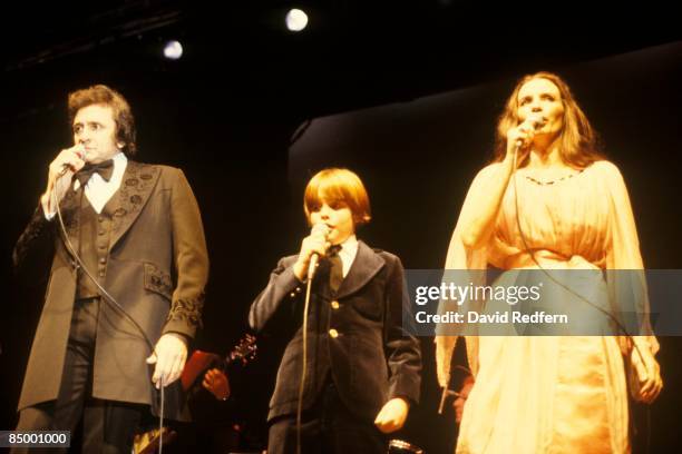 Photo of John Carter CASH and June CARTER and Johnny CASH; Johnny Cash performing on stage with wife June Carter Cash and their son John Carter Cash