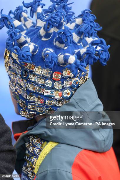 Young Everton fan shows off his collection of match day enamel badges before kick-off