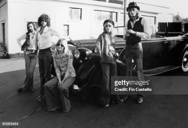 Photo of FLEETWOOD MAC, L-R: John McVie, Lindsey Buckingham, Christone McVie, Stevie Nicks, Mick Fleetwood - posed, group shot, by car - MusicBrainz:...