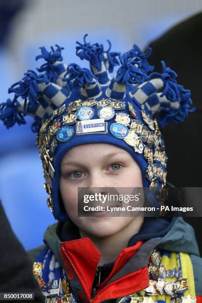 Young Everton fan shows off his collection of match day enamel badges before kick-off