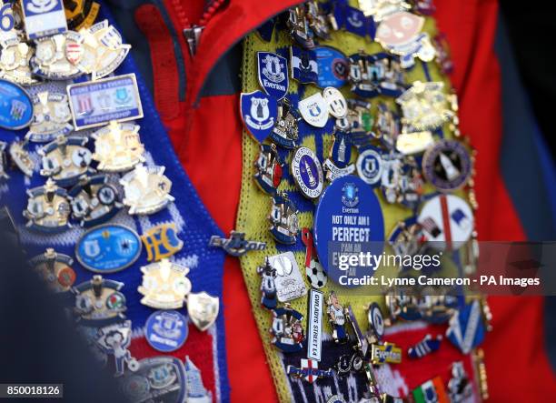 Young Everton fan shows off his collection of match day enamel badges before kick-off
