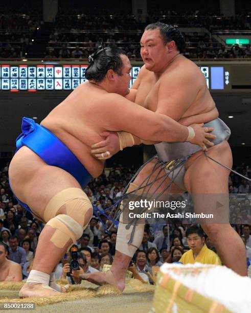 Kotoshogiku pushes Hokutofuji out of the ring to win during day eleven of the Grand Sumo Autumn Tournament at Ryogoku Kokugikan on September 20, 2017...