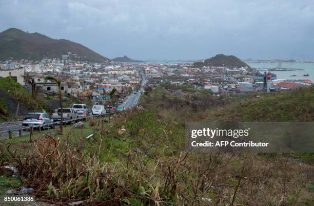 Cars ride in on September 20 in Marigot, on the French side of the Caribbean island of Saint-Martin, after hurricane Maria and Hurricane Irma hit the...