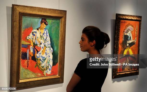 Woman studies the Andre Derain painting of Madame Matisse au Kimono painted in 1905, with a painting by Picasso titled Buste d'homme a la pipe. The...