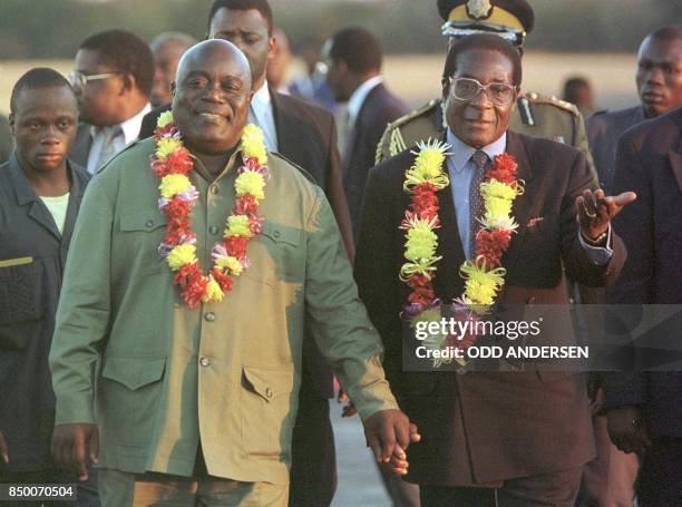 President Laurent Kabila of the Democratic Republic of Congo is guided, 07 August by his Zimbabwean counterpart Robert Mugabe upon his arrival at...