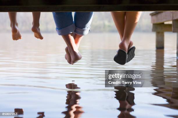 multi-generational men relaxing on boat dock - contemplation family stockfoto's en -beelden