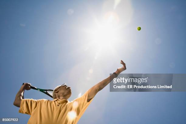 african man playing tennis - senior tennis stock pictures, royalty-free photos & images