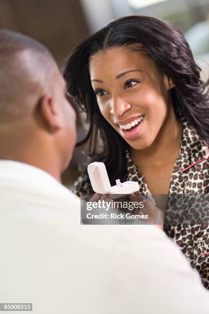 african man giving girlfriend engagement ring - esperanza gomez fotografías e imágenes de stock