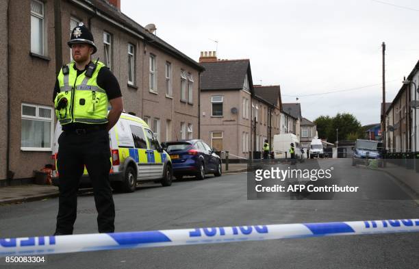 Police officer stands guard at a police cordon near to a house in Newport, south Wales, on September 20 as they continue their investigations into...