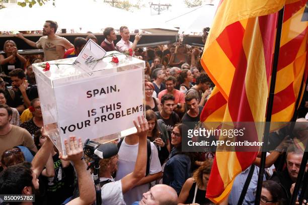 Two people carry a symbolic ballot box during a protest in front of Catalonia's regional government economy headquarters in Barcelona on September...